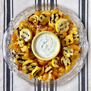 Summer salad with grilled squash and corn on glass dish