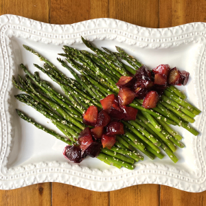 Asparagus and plums on white plate