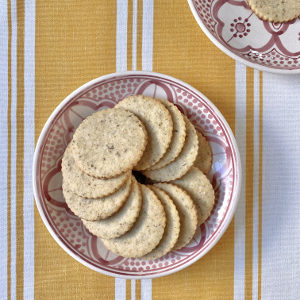 Chamomile cookies on pink and white plate with yellow striped background