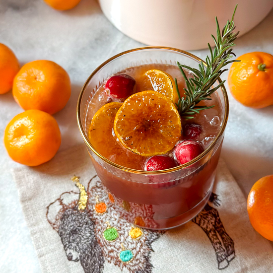Cranberry orange mocktail with ginger and garnished with rosemary