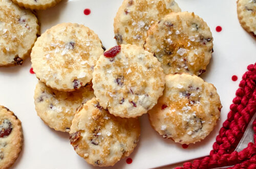 Cranberry shortbread cookies on a holiday plate with a red trimmed napkin