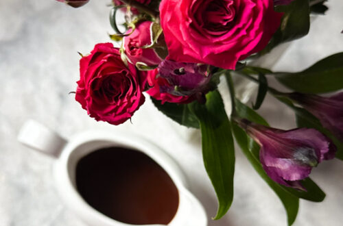 Chocolate balsamic vinaigrette in a white container surrounded by roses