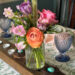 Spring bouquet on an Easter table set with blue glasses and a floral tablecloth